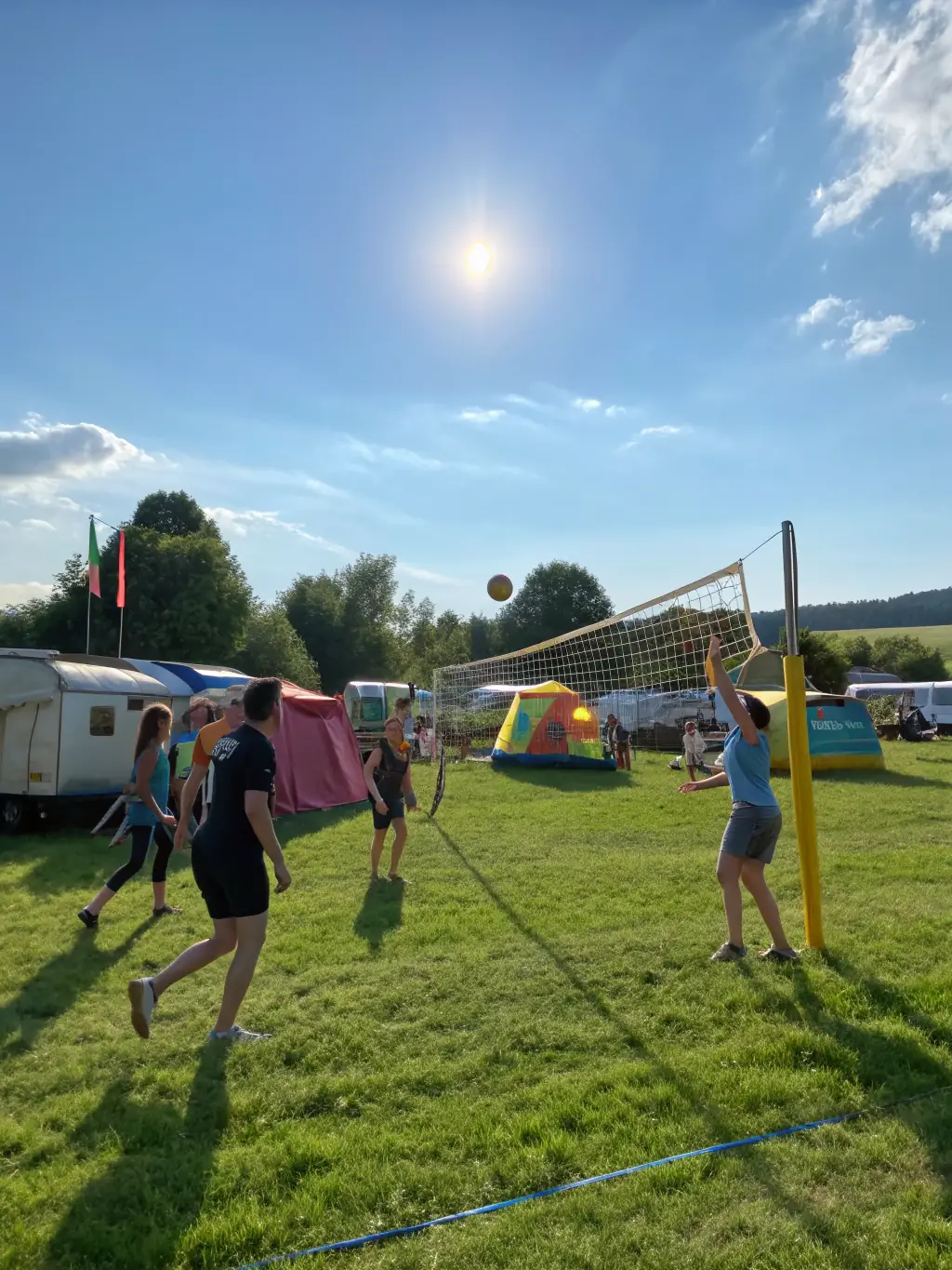A dynamic photo of adults playing volleyball in a local park, emphasizing teamwork, physical activity, and the joy of sports at UNION LAIQUE DE MIRIBEL.